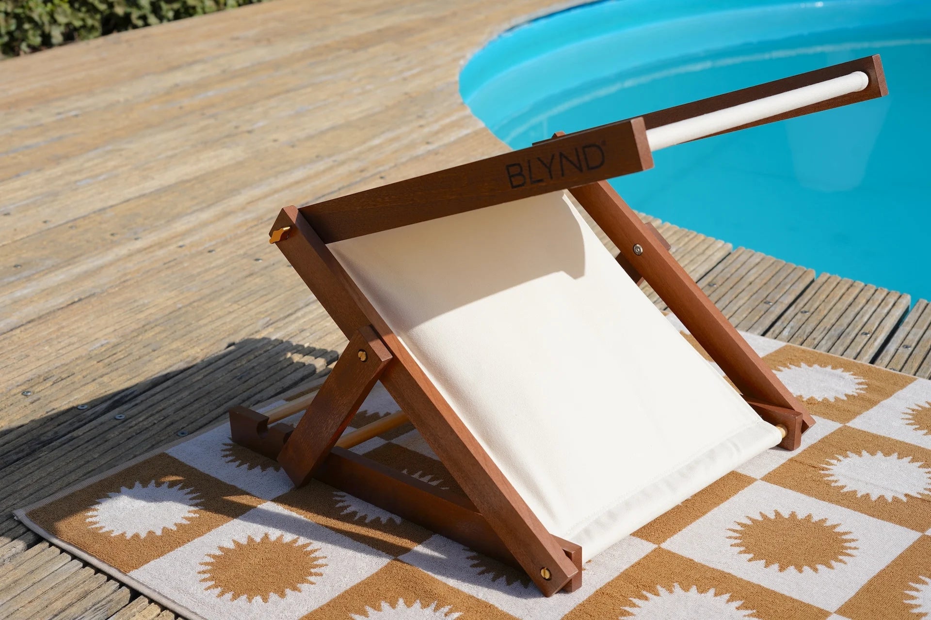 BLYND Premium Portable Beach Head Shade on towel near swimming pool with built-in pillow and sun visor