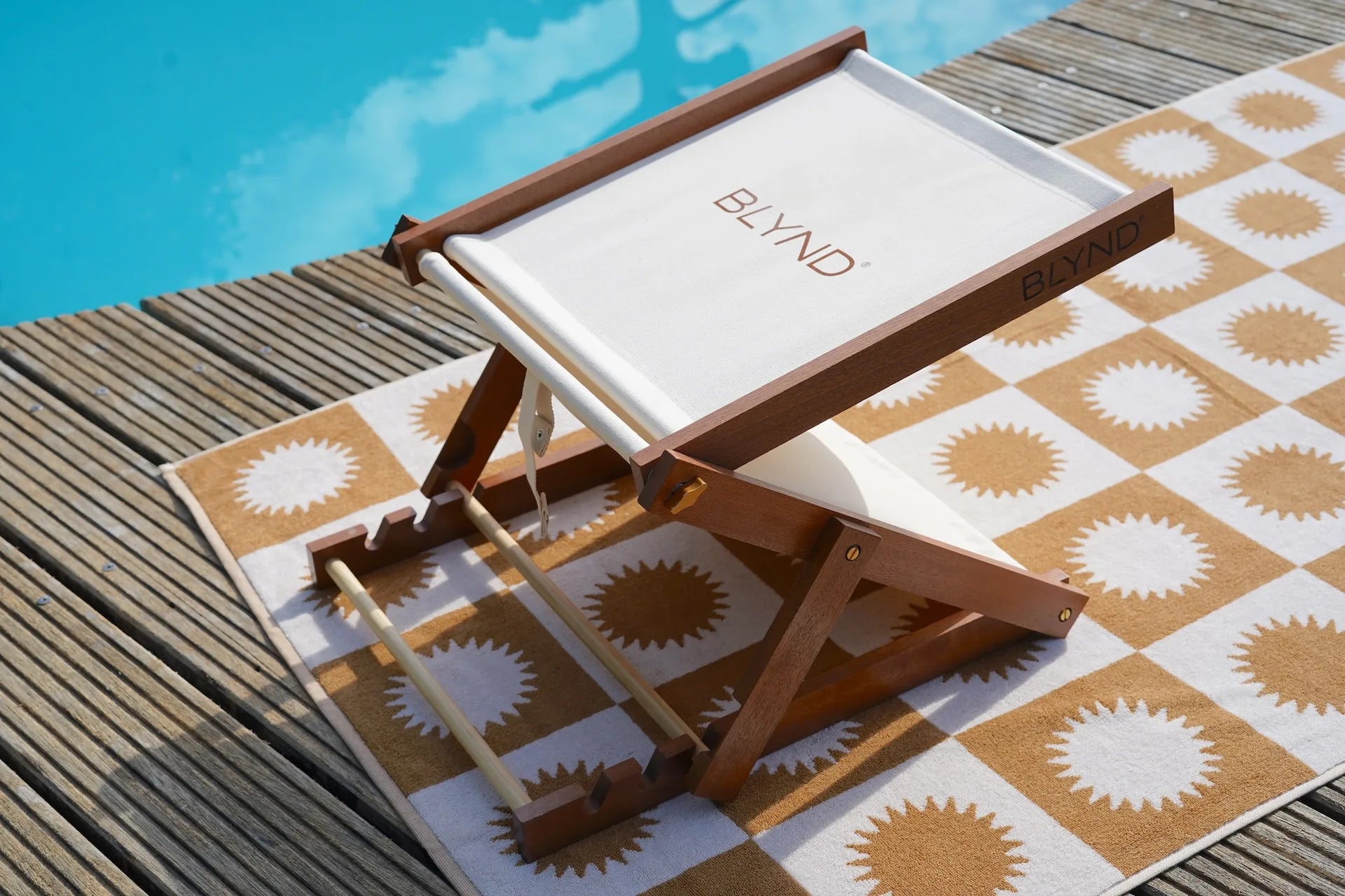 BLYND Premium Portable Beach Head Shade on towel near swimming pool sun shade.