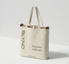 Beige tote bag with folded wooden beach head shade and bottom, featuring BLYND branding and getblynd.com website.